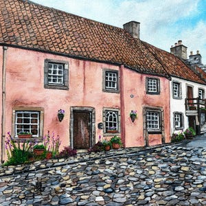 May include: A watercolor painting of a row of colorful houses on a cobblestone street. The houses are painted in shades of pink, white, and yellow. The street is lined with trees and flowers.