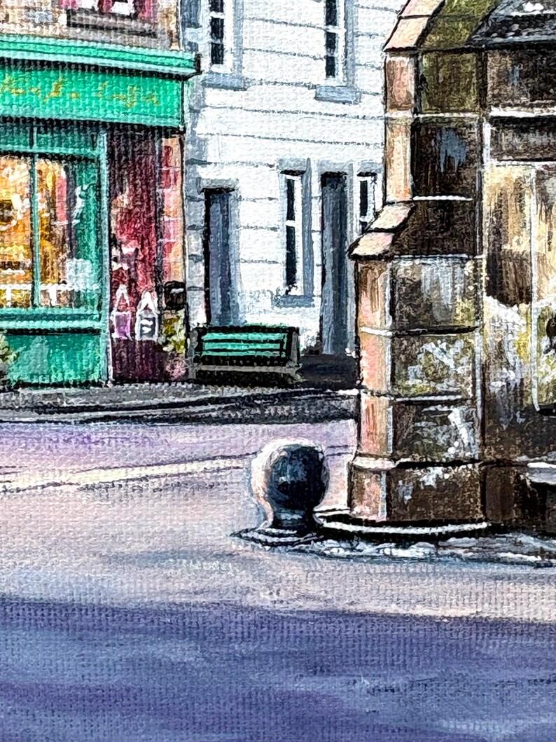 May include: Watercolour painting of a European street scene. Buildings with white and brown facades, a green awning, and a bench. The street is light purple, with a bollard in the foreground. A quaint, artistic depiction.