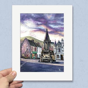 May include: Watercolour painting of a Scottish town square featuring a stone cross monument. Buildings with shops and homes surround the square. The sky is a mix of purple and grey clouds. A green hill is in the background.