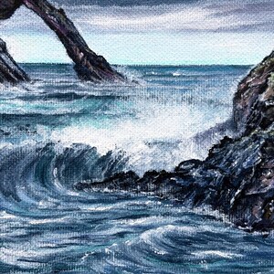 May include: An acrylic painting depicts a seascape with crashing waves and rocky cliffs. The artwork features shades of blue and white, capturing the movement of the water and the texture of the rocks. A natural arch is visible in the background.