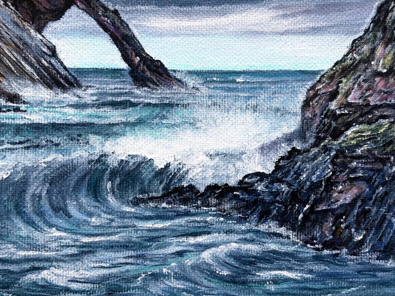 May include: An acrylic painting depicts a seascape with crashing waves and rocky cliffs. The artwork features shades of blue and white, capturing the movement of the water and the texture of the rocks. A natural arch is visible in the background.