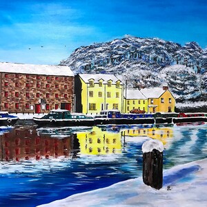 May include: A painting depicting a canal scene with snow-covered buildings and a snowy hill in the background. The buildings are yellow and red brick with white snow on the roofs. There are boats moored along the canal and a wooden post with snow on top in the foreground.