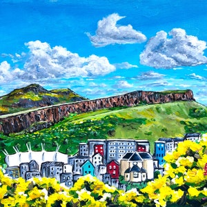 Puede incluir: Una pintura de un horizonte urbano con una gran colina en el fondo. La ciudad está pintada en una variedad de colores, incluyendo rojo, azul, verde y amarillo. La colina está pintada en tonos de marrón y verde. El cielo es azul con nubes blancas. La pintura está enmarcada en un marco blanco.