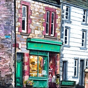 May include: A painting depicting a street scene with a shop. The shop has a green awning and door, with stone walls and red-framed windows. The shop window reveals a warm interior. A white building is next to it.