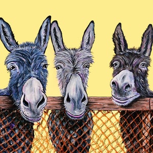 May include: Three donkeys peek over a wooden fence with a wire mesh. The donkeys have gray and black fur and are looking at the camera. The background is a pale yellow.