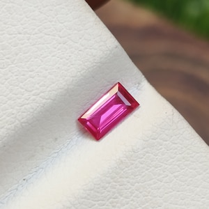 Może przedstawiać: Różowy prostokątny kamień szlachetny o fasetowanym szlifie.