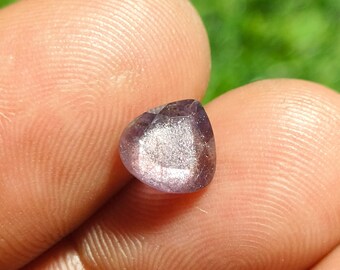 May include: A heart-shaped gemstone with a sparkly, iridescent finish. The stone is a light purple color with a hint of pink.
