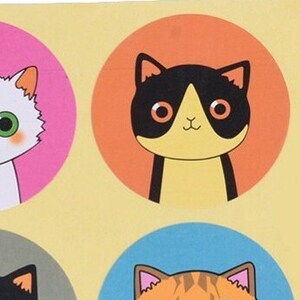 May include: Four colorful stickers featuring cartoon cats. Each sticker has a different colored background and a different cat design. The cats are all smiling and have big eyes.