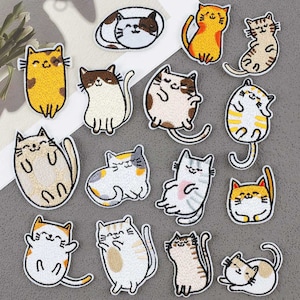 May include: A set of 15 iron-on patches featuring various cute cat designs. The patches are in a variety of colours, including yellow, white, brown, black, and pink. The patches are perfect for adding a touch of whimsy to clothing, bags, or other accessories.