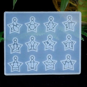 Può includere: Uno stampo in silicone trasparente con 12 cavità a forma di stella. Ogni cavità presenta un design diverso con un anello nella parte superiore.