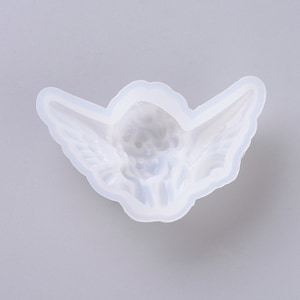 Könnte beinhalten: Eine weiße Silikonform in Form eines Engels mit Flügeln. Die Form ist dazu bestimmt, eine Engelsfigur aus Harz oder Polymer Clay zu erstellen.