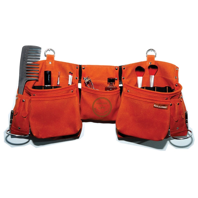 May include: Orange canvas tool belt with multiple pockets and loops. The belt has a comb, makeup brushes, and bottles in the pockets.