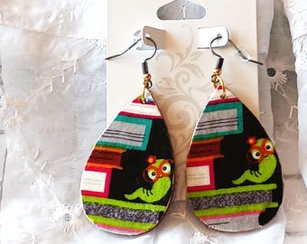 May include: A pair of teardrop-shaped earrings with a colorful fabric design. The earrings feature a black background with a green worm-like creature and a pattern of red, white, and gray stripes. The earrings hang from silver-colored hooks.