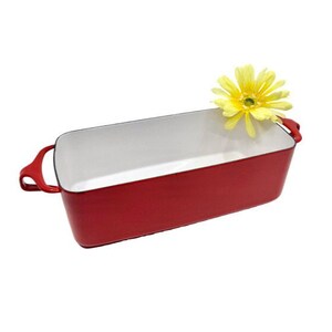 May include: A rectangular red baking dish with white interior and handles. A yellow flower rests on the rim. The dish is designed for baking and serving.