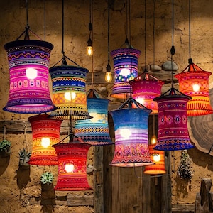 May include: A collection of colorful, patterned pendant lamps hanging from the ceiling. The lampshades feature vibrant designs in shades of pink, blue, orange, and red. Each lamp has a lightbulb inside, illuminating the intricate patterns.