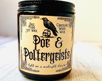 May include: A dark brown glass jar candle with a black lid. The label features a raven perched on a skull, with the words "Poe & Poltergeists" and "light on a midnight dreary". The candle contains 8 oz of soy wax.