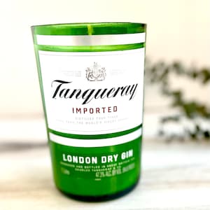 Op de afbeelding: Een groene glazen kaars pot met een wit label waarop "Tanqueray Geïmporteerd" en "London Dry Gin" staat.