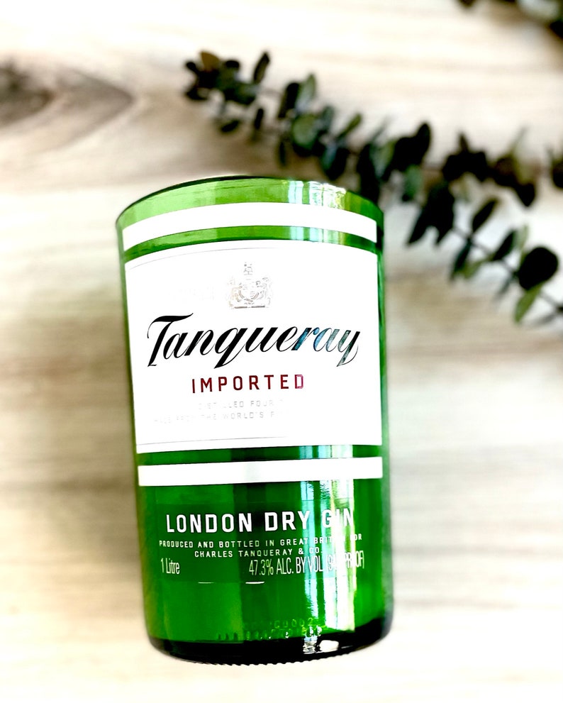 Może przedstawiać: Zielona szklana butelka Tanqueray Imported London Dry Gin. Butelka ma białą etykietę z nazwą marki i słowami "Importowany" i "London Dry Gin". Butelka ma pojemność 1 litra i zawiera 47,3% alkoholu.