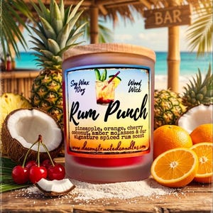 Puede incluir: Un tarro de vela de vidrio esmerilado con tapa de madera, etiquetado "Rum Punch". La etiqueta presenta una ilustración de cóctel y enumera ingredientes. Frutas tropicales como piña, naranjas y cerezas rodean la vela.