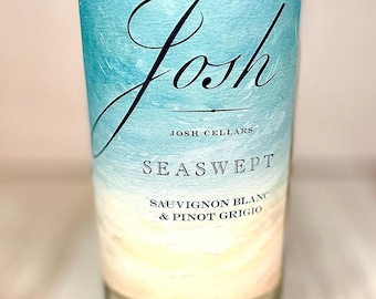 May include: A clear wine bottle with a label featuring the word "Josh" in a script font. The label has a blue and white watercolor design with the words "Seaswept", "Sauvignon Blanc & Pinot Grigio", and "Josh Cellars".