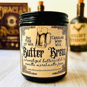 Könnte beinhalten: Ein Glas-Kerze mit schwarzem Deckel und einem Etikett mit der Aufschrift "Butter Brew". Das Etikett zeigt eine Bierkrug-Illustration und den Text "caramelized butterscotch & vanilla marshmallow foam". Die Kerze ist 227g und aus reinem Sojawachs hergestellt.