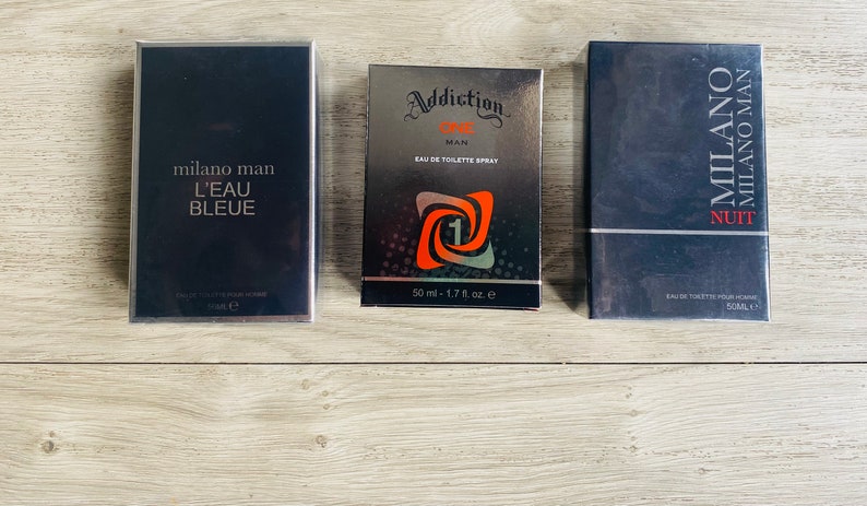Puede incluir: Tres botellas de colonia con envases plateados y negros. Las botellas est&aacute;n etiquetadas con "Milano Man L'Eau Bleue", "Addiction One Man Eau de Toilette Spray" y "Milano Milano Man Nuit".