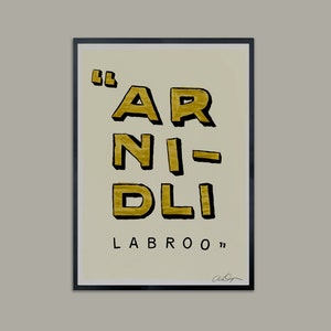 May include: A framed print with a white background and black frame. The print features gold text that reads "'AR NI-DLI LABROO'".