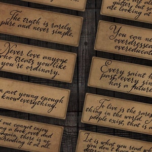 Puede incluir: Un conjunto de 14 tarjetas de estilo vintage con citas inspiradoras impresas en ellas. Las tarjetas son marrones con texto negro y tienen un aspecto desgastado. Las citas incluyen: "Sé tú mismo, todos los demás ya están cogidos." "La verdad es rara vez pura y nunca simple." "Nunca ames a nadie que te trate como si fueras ordinario." "No soy lo suficientemente joven para saberlo todo." "Si uno no puede disfrutar leyendo un libro una y otra vez, no tiene sentido leerlo en absoluto." "Amarse a sí mismo es el comienzo de un romance de por vida." "¿Quién, siendo amado, es pobre?" "Todos estamos en la cuneta, pero algunos de nosotros estamos mirando las estrellas." "Nunca puedes estar demasiado vestido o demasiado educado." "Todo santo tiene un pasado, todo pecador tiene un futuro." "Vivir es lo más raro del mundo. La mayoría de la gente existe, eso es todo." "Es lo que lees cuando no esperas que eso determine dónde estarás cuando no puedas evitarlo." "Con libertad, flores, libros y la luna, ¿quién no podría ser perfectamente feliz?" "Algunas cosas son más preciosas porque no duran mucho."