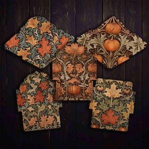 May include: Five decorative coasters with fall-themed designs. The coasters feature patterns of orange pumpkins and autumn leaves in shades of orange, yellow, and green. The coasters are arranged on a dark wood surface.