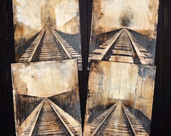 May include: Four abstract art pieces depicting railroad tracks receding into the distance. The artwork features a sepia-toned color palette with shades of brown, beige, and black. The pieces are mounted on a dark wooden surface.