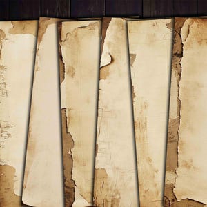 May include: A collection of aged paper sheets with torn edges, arranged against a dark wood background. The paper has a vintage, weathered appearance with a beige color and brown accents, suggesting a historical or antique theme.