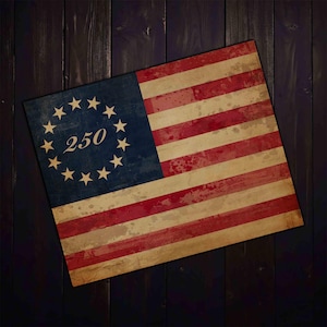 Pode incluir: Uma bandeira americana em estilo vintage com 13 listras vermelhas e brancas e um cantão azul com 13 estrelas em círculo. O número "250" está no centro das estrelas. A bandeira tem uma aparência envelhecida.