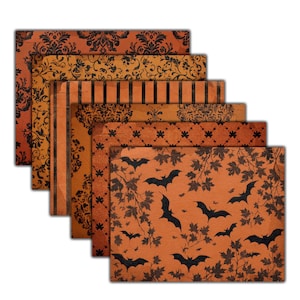 May include: A stack of six Halloween-themed paper sheets with various patterns. The designs include black damask, stripes, and bat silhouettes on orange and tan backgrounds. The papers are arranged in a layered fan shape.