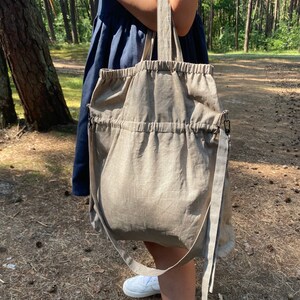 Linen tote bag. Handmade from waxed linen. The bag is rectangular shape with short handles and shoulder strap, has inside pocket for phone and wallet. The tote bag closes with side straps.
