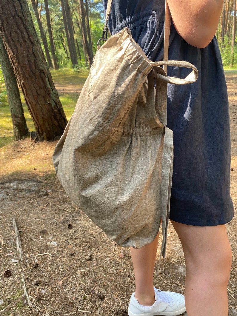 Linen tote bag. Handmade from waxed linen. The bag is rectangular shape with short handles and shoulder strap, has inside pocket for phone and wallet. The tote bag closes with side straps.