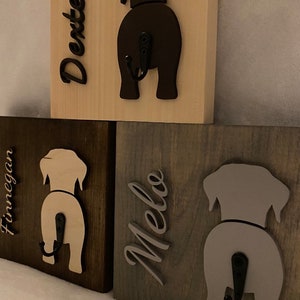May include: Three wooden dog-shaped hooks with names "Dexter", "Finnegan", and "Melo" written on them. Each hook has a black metal hook.