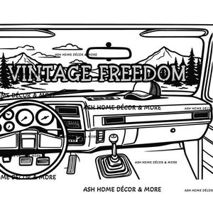以下が含まれることがあります： 「VINTAGE FREEDOM」の文字がフロントガラスに書かれた、車の内装の白黒イラスト。ダッシュボードにはキャップが置かれ、フロントガラスを通して山と森の風景が見える。
