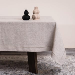 Mantel de lino belga personalizado con borde bordado para comedor de lujo.