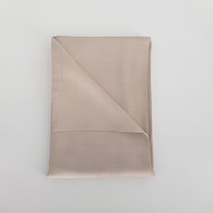 May include: A folded beige linen fabric. The fabric has a smooth, even texture.