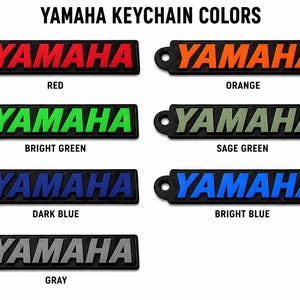 Pu&ograve; includere: Una collezione di portachiavi Yamaha in vari colori, tra cui rosso, arancione, verde brillante, verde salvia, blu scuro, blu brillante e grigio. Ogni portachiavi presenta il logo Yamaha.