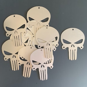 May include: A set of eight metal cutouts in the shape of the Punisher skull. The cutouts are all the same size and shape, and they are all made of a silver-colored metal.
