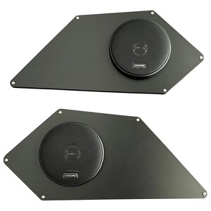 May include: Two black car audio speaker enclosures. Each enclosure has a unique geometric shape with a circular speaker and the Alpine logo. The speakers are mounted with small silver screws.