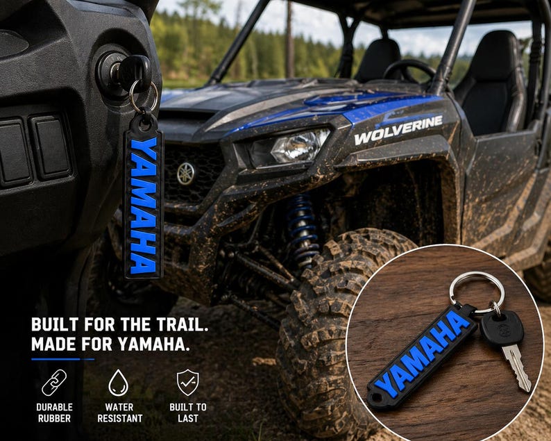 Pu&ograve; includere: Portachiavi Yamaha nero e blu con la scritta "YAMAHA" in blu. Il portachiavi &egrave; attaccato a una chiave nell'accensione di un ATV Yamaha Wolverine. &Egrave; visibile anche il testo "BUILT FOR THE TRAIL. MADE FOR YAMAHA.".