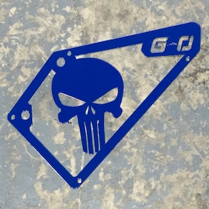 May include: Blue metal plate with a cutout of a skull and crossbones. The plate has a small logo that says "G-D" in the top right corner.