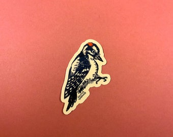 Puede incluir: Una ilustración en blanco y negro de un pájaro carpintero con una corona roja. La ilustración está sobre un fondo beige con el texto "SOLSTICE HANDMADE" en negro.