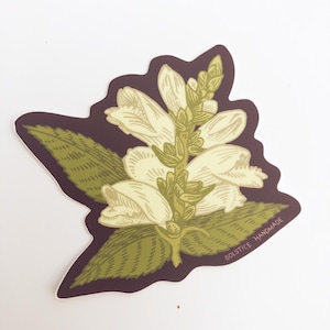 May include: A sticker featuring a botanical illustration of a white flower with green leaves and stems. The flower is set against a dark purple background, with the text "SOLSTICE HANDMADE" printed in white along the bottom edge. The sticker has a die-cut shape.