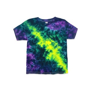 May include: A short-sleeved tie-dye t-shirt in a vibrant color scheme. The shirt features a central streak of bright yellow, flanked by swirls of green, purple, and dark blue. The fabric is soft and the design is eye-catching.