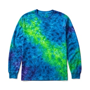 May include: A long-sleeve crew neck shirt featuring a tie-dye pattern in shades of blue, lime green, and dark purple. The design displays a diagonal band of bright lime green stretching across the chest, surrounded by deep blue and purple tones.