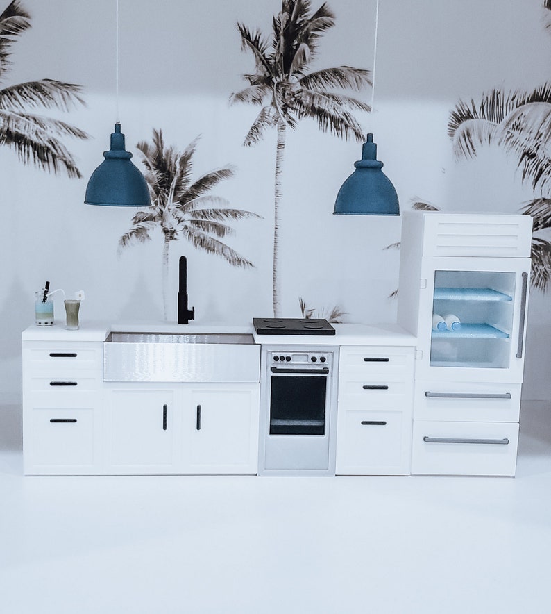 May include: A white kitchen with a stainless steel sink, a white oven, and a white refrigerator. The kitchen has a black faucet and a black stovetop. There are two blue pendant lights hanging above the sink.