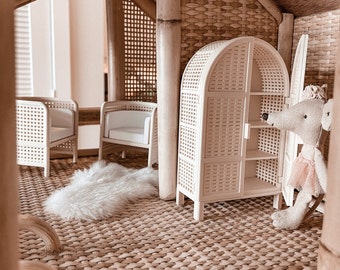 May include: A dollhouse interior with a woven rattan floor, two wicker chairs, a white wicker armoire, and a plush toy mouse wearing a pink tutu.